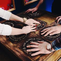 The hands of young people move pieces of the Mexican style trying to get out of the trap, escape the room game concept